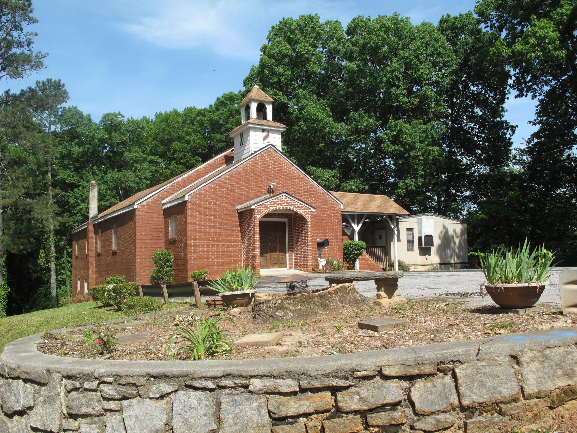 A small, red brick Christian church sits on a small lot. Mount Pleasant Baptist Church on Porter Road in DeKalb County, Georgia.